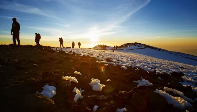 Climbers walking towards the summit of Kilimanjaro at dawn