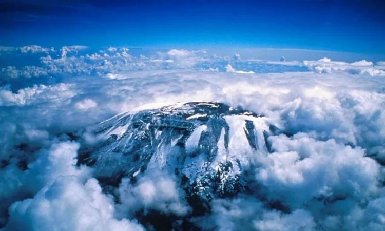 Aerial view of Kilimanjaro’s snowy summit surrounded by clouds