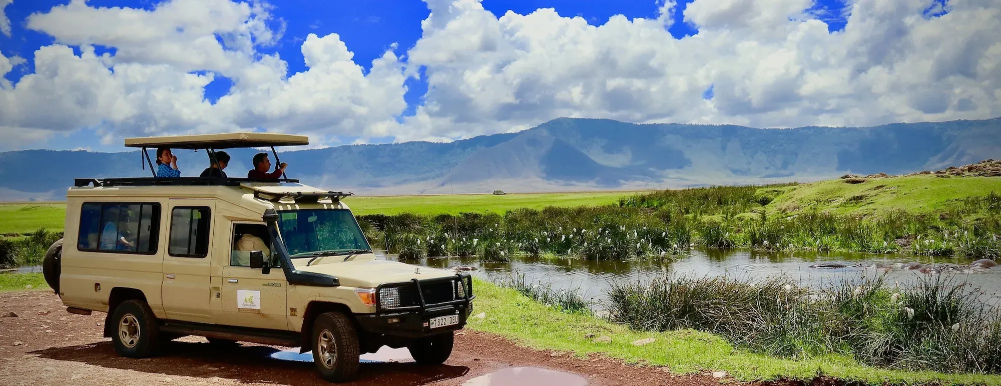 Safari vehicle beside a river on the Ngorongoro Crater floor