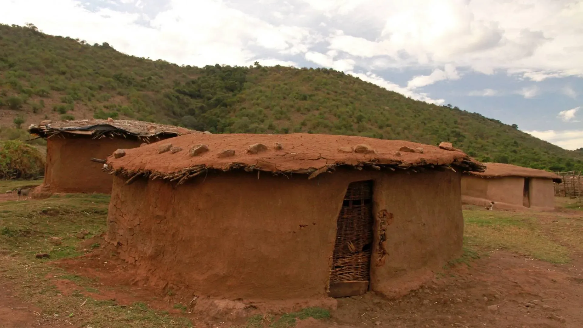 Traditional mud hut on a green hillside